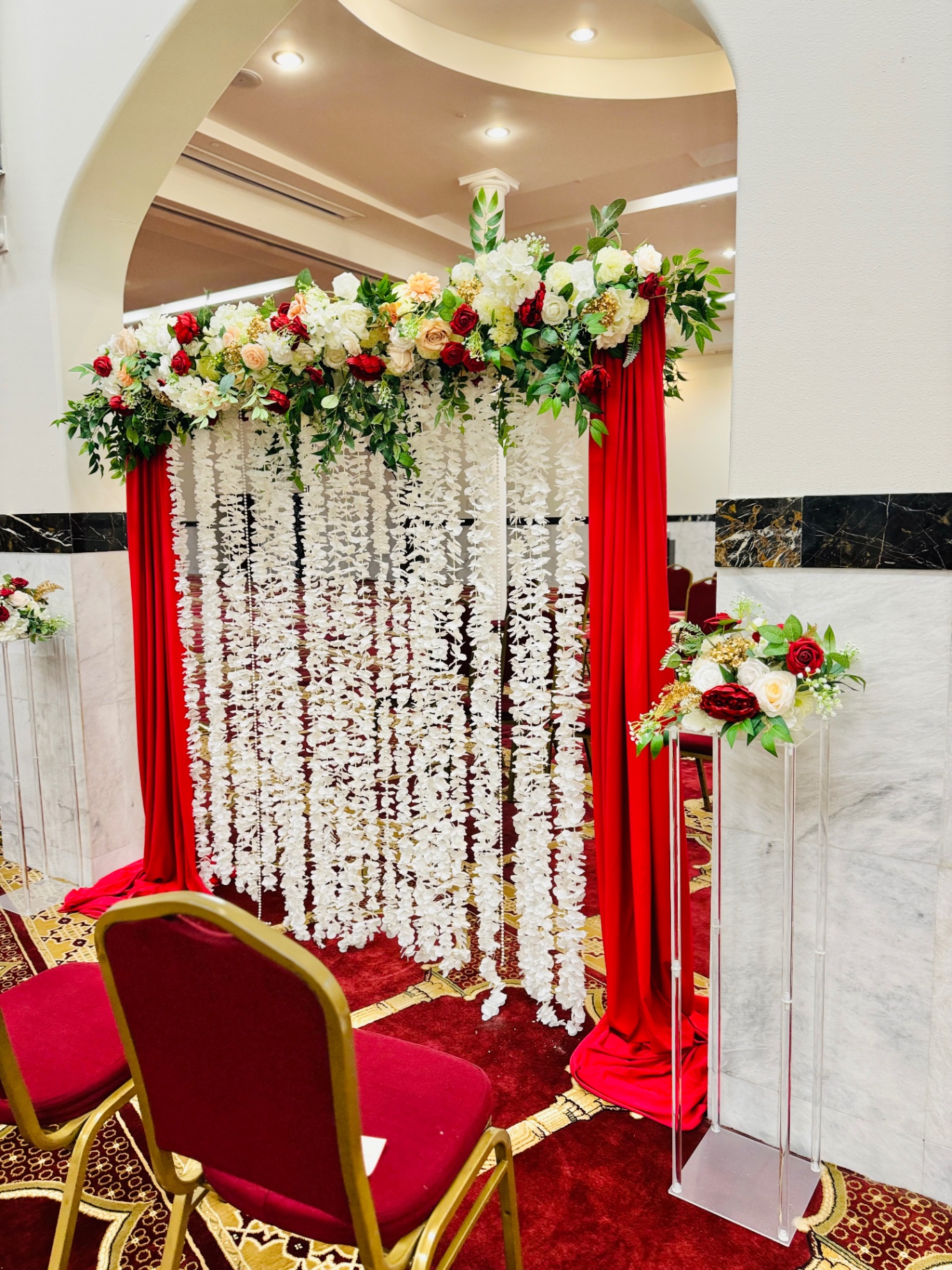 Red drape & white jasmine cascade arch